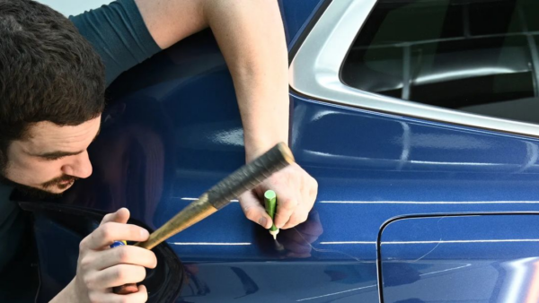paintless dent repair on a blue sedan